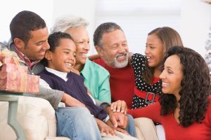 Three generations of a wealthy African-American family smiling together.