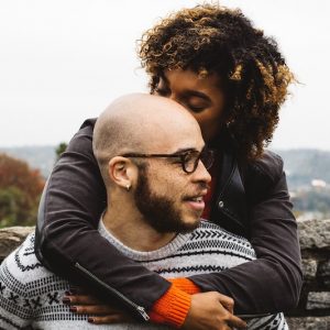 African-American couple. Woman kissing man on head.