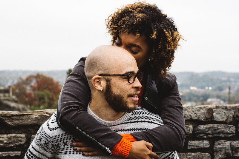 African-American couple. Woman kissing man on head.